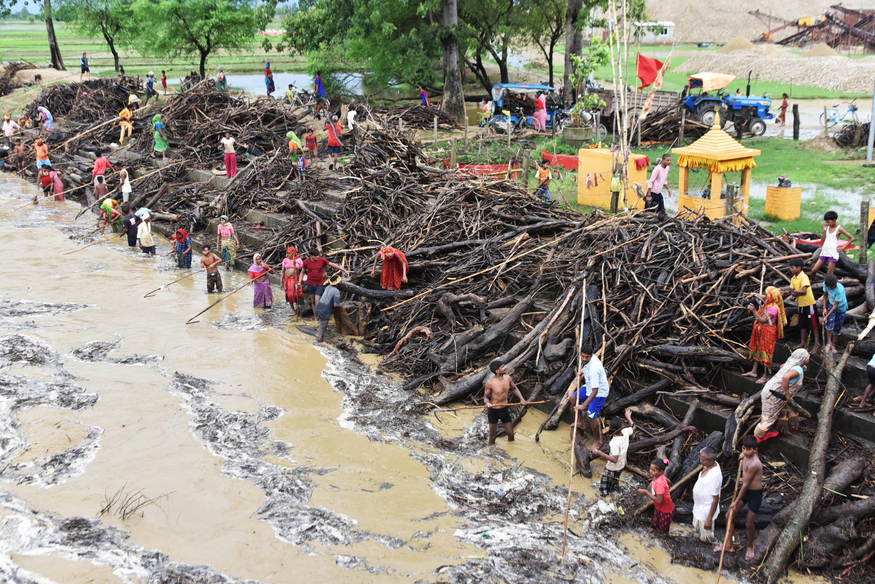 उर्लिएको राप्तीमा जोखिम मोलेर दाउरा झिक्दै स्थानीय